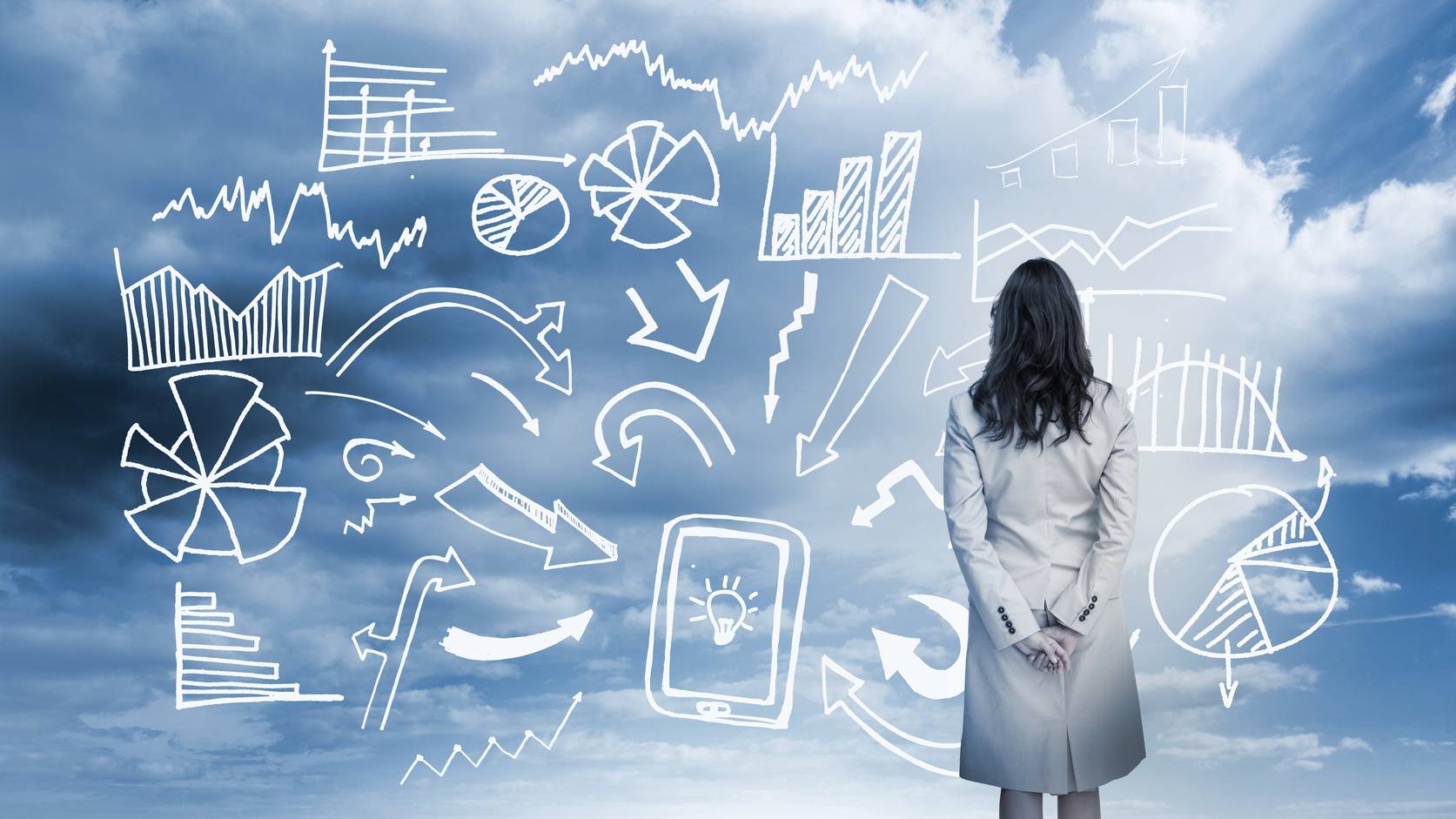 Businesswoman standing looking at data flowchart in cloudy landscape